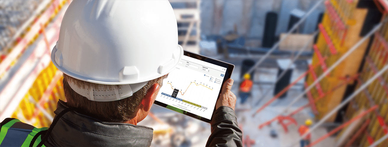 Worker with IPad above a worksite