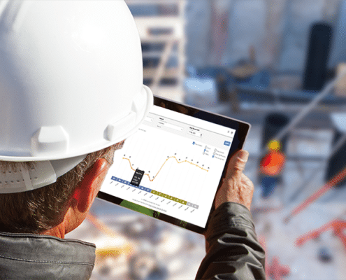 Worker with IPad above a worksite